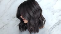 Young Asian woman with trendy dark gray wavy bob haircut shown in profile against marble background, demonstrating modern hair coloring and styling technique.