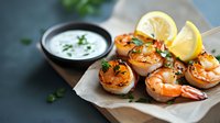 Grilled shrimp skewers with lemon slices and creamy dipping sauce on rustic wooden board, perfect for seafood appetizers or summer entertaining.