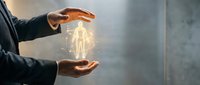 Businessman hands protecting glowing human figure symbolizing healthcare insurance, employee protection and corporate wellness programs.