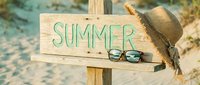 Wooden arrow sign with Summer text, straw hat and sunglasses on sandy beach, warm vacation mood for travel and seasonal greeting designs.