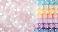 Colorful rows of shimmering pastel beads with bokeh background create dreamy romantic composition. Soft focus macro photography shows delicate texture and light.