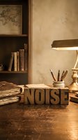 Vintage wooden letterpress blocks spelling NOISE on antique desk with brass lamp, old books and writing tools in warm atmospheric study room setting.
