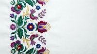Colorful folk art floral border with traditional embroidery style flowers and leaves on white background for textile design and decorative projects.