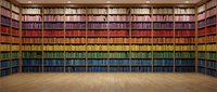 Spectacular rainbow library with color-coordinated books arranged in gradient from red to blue on wooden shelves in elegant reading room with parquet flooring.