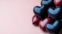 Romantic composition of glossy black and red heart shapes arranged on neutral background, creating elegant Valentine's day or love concept design element.