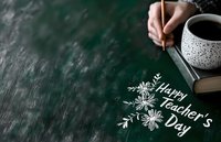 Hand writing "Happy Teacher's Day" with chalk on dark green chalkboard, alongside decorative floral elements, coffee mug, and notebook.