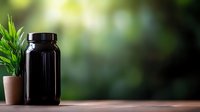 Black supplement container and potted plant on wooden surface against blurred green natural background, minimalist wellness composition for healthy lifestyle products.