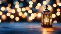 Glowing ornate lantern on dark surface against blurred warm bokeh lights background creates magical atmospheric mood for holiday celebrations and events.