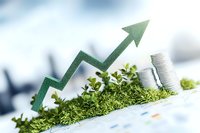 Green arrow trending upward with stacked coins on moss, representing sustainable financial growth and eco-friendly business success on blurred background.