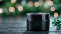 Black cosmetic jar on dark wooden surface with bokeh lights and green foliage in background creates luxurious spa atmosphere for beauty product photography.