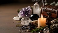 Spiritual healing crystals amethyst quartz with burning candle sage smudge sticks and wooden treasure box for meditation wellness rituals and energy cleansing.