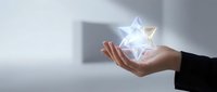 Business professional hand holding glowing geometric star shape with light effects against modern office background for corporate success concepts.