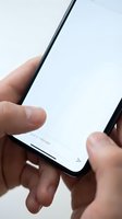 Close-up hands holding modern smartphone with blank white screen ready for app mockup and digital interface design presentations.