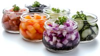 Colorful pickled vegetables in glass jars including red onions, carrots, cucumbers arranged in row. Fresh herbs garnish adds gourmet appeal to preserved food.