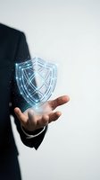 Businessman holding glowing digital shield hologram representing cybersecurity protection and data safety in modern technology concept.