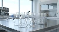 Modern laboratory interior with glass beakers, flasks and test tubes on white counter. Clean scientific workspace for research, analysis and experiments.