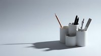 Modern minimalist desk organizer with pencils and pens on clean white background for office workspace design and productivity concepts.