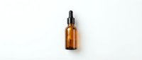Amber glass dropper bottle with black pipette cap isolated on white background for skincare serum, essential oil or cosmetic product packaging design.