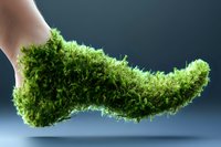 Green moss growing on human foot against dark background, environmental concept showing nature reclaiming form, creative ecological photography.