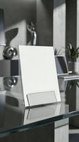 Modern acrylic document holder stand on glass desk in contemporary office workspace with natural lighting and minimalist design elements.