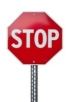 Red octagonal stop sign with white lettering mounted on metal pole against white background, isolated for easy integration into design projects.
