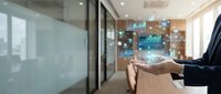 Businessman holding smartphone with digital network icons and data visualization in modern office environment for technology and communication concepts.