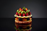 Decadent chocolate cake with fresh strawberries and blackberries on dark background for bakery menu design and dessert advertising campaigns.