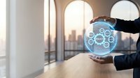 Business professional holding glowing digital sphere with network icons in modern office overlooking city skyline at sunset for technology presentations.