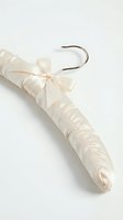 Elegant ivory satin padded clothes hanger with a delicate bow and silver metal hook, isolated on white background, ready for design use.