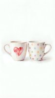 Two ceramic mugs with watercolor designs on white background. Left mug features red heart, right mug displays colorful polka dots. Isolated drinkware for merchandise, home decor, and product design.