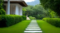 Modern house with manicured garden pathway leading through perfectly trimmed hedges and lush green lawn toward mountain landscape backdrop.