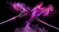 Makeup brushes with vibrant purple and pink powder explosion on black background for cosmetic and beauty industry advertising campaigns.