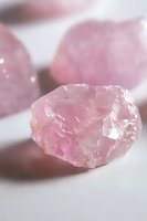 Raw rose quartz crystal on white background showcasing natural pink hues and translucent mineral formation, suitable for wellness and spiritual content.