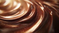Smooth swirling chocolate background with rich brown and caramel tones creates luxurious texture pattern. Silky melted cocoa surface with glossy waves and ripples for confectionery designs.