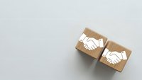Two wooden blocks with handshake icons symbolizing business partnership, cooperation and agreement concepts for corporate presentations.