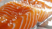 Fresh raw salmon fillet with water droplets in macro view showing detailed texture and layers of orange fish meat, healthy seafood preparation.