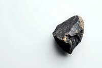 Raw black coal chunk with rough texture and natural fractures on white background, isolated mineral specimen showing geological details and industrial material.