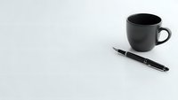 Black coffee mug and elegant pen on clean white surface for business workspace mockup and professional office branding materials.