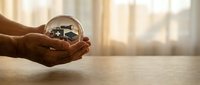Young professional with dark skin tone holding a crystal sphere containing a miniature office workspace, symbolizing business vision and entrepreneurial goals for corporate and startup concepts.