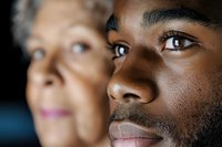 Close-up portrait of young African American man with elderly Caucasian woman in background showing intergenerational connection and family bonds.