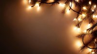 Glowing Christmas lights and pine branches create magical corner border frame on dark brown background, festive holiday illumination and decor.