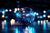 Shiny disco ball reflecting blue light against dark background with blurred bokeh lights creating nostalgic party atmosphere for nightclub and entertainment designs.