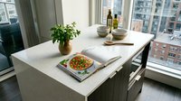 Minimalist dining table setup with fresh salad, olive oil bottles, potted herbs, and city skyline view through windows. Modern kitchen interior design.