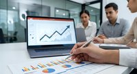 Business team analyzing financial data and growth charts on laptop during corporate meeting in modern office conference room.