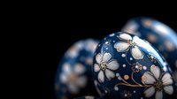 Elegant navy blue Christmas ornaments with delicate white floral pattern and gold accents against dark background create festive holiday atmosphere.