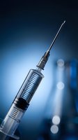 Medical syringe with needle on blue background for healthcare and vaccination concepts in clinical laboratory setting.