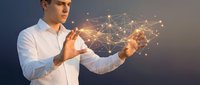 Young Caucasian businessman in white shirt holding glowing digital network connections with light nodes and lines representing technology innovation.
