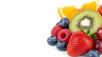 Fresh mixed fruits including strawberry, kiwi, orange, blueberries and raspberries on white background for healthy eating and nutrition concepts.