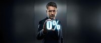 Businessman in formal suit and glasses pointing at zero percent symbol, isolated on dark background for business, finance, and marketing concepts.