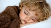 Peaceful sleeping blonde toddler wrapped in cozy brown fleece blanket resting on white pillow, soft natural lighting creates gentle mood for childhood themes.